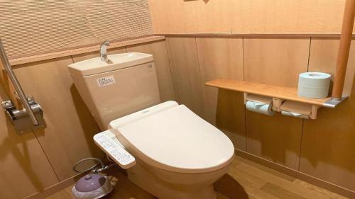 a small bathroom with a toilet with a remote control at Hotel Miyama in Chichibu