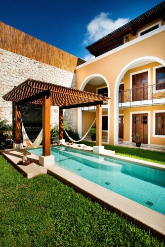 a swimming pool in front of a house at Boutique by The Museo in Mérida