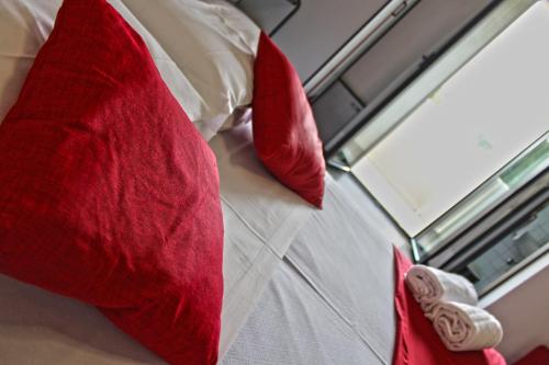 a bed with red pillows on it with a window at Park Hotel in Castrocaro Terme