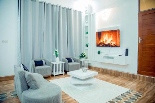 a living room with two chairs and a fireplace at Stand-alone- 2BR house in Dodoma in Dodoma