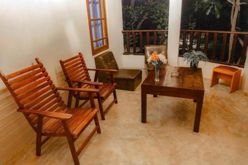 a living room with two chairs and a table and a table at Harmony Beach Bangalow in Tangalle