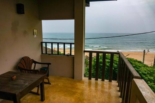 a balcony with a table and a view of the beach at Harmony Beach Bangalow in Tangalle