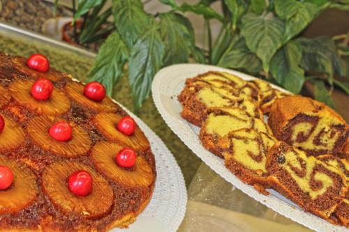 a cake with cherries on top of it next to a plate at Park Hotel in Castrocaro Terme