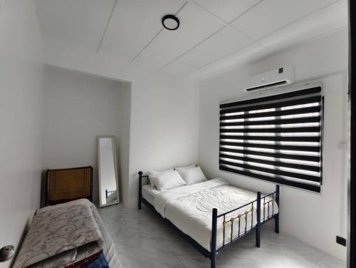 a bedroom with a bed and a window at Nenda NZ Homestay in Tanjung Karang