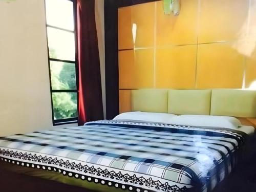a bed sitting in a room with a window at Admiral Hotel in Sitiawan