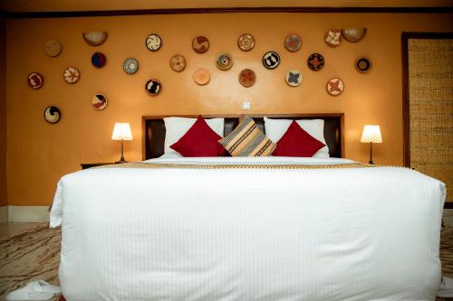 a bedroom with a large white bed with red pillows at Mountain Gorilla View Lodge in Ruhengeri