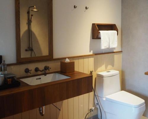 a bathroom with a toilet and a sink at Chann Bangkok Noi in Bangkok