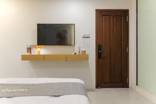 a bedroom with a tv on a wall with a bed at Mono Coliving Kota Tua, Jakarta in Jakarta