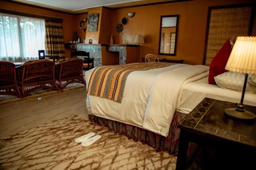 a bedroom with a large bed and a living room at Mountain Gorilla View Lodge in Ruhengeri