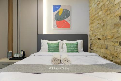 a bedroom with a bed with two towels on it at Mono Coliving Kota Tua, Jakarta in Jakarta