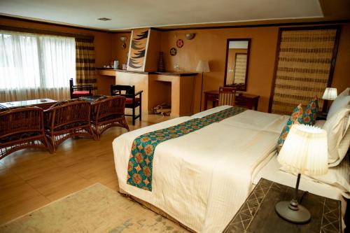 a bedroom with a large bed and a living room at Mountain Gorilla View Lodge in Ruhengeri