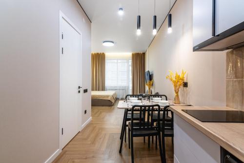a kitchen and dining room with a table and chairs at Светлая квартира-студия в 5-минутах от Мега Парк in Almaty