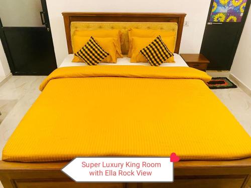 a yellow bed with yellow sheets and pillows at The Rock Face in Ella