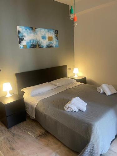 a bedroom with a bed with two towels on it at M&J house in Reggio Calabria