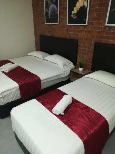 a room with two beds with red and white sheets at Rock & Roll Hotel Klang in Klang