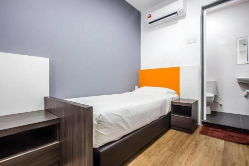 a small bedroom with a bed and a mirror at Big Orange Hotel Jitra in Alor Setar
