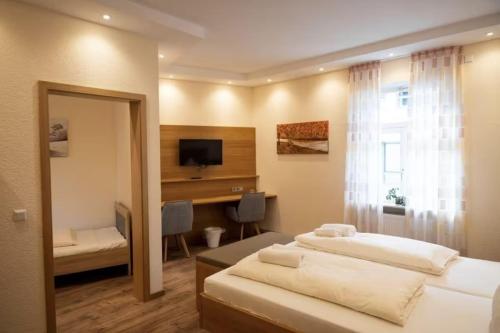 a bedroom with two beds and a desk and a window at Gasthause Zur Krone Hotel in Leimen