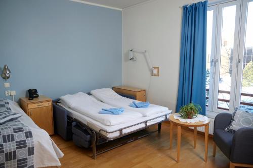 a room with a bed and a table and a window at Unicare Røros in Røros