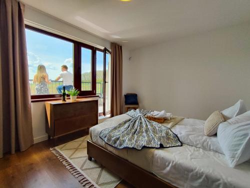 a bedroom with a bed and a large window at Pensiune și Restaurant Silvania in Poiana Măgura