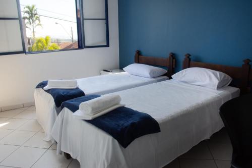 two beds sitting next to each other in a room at Hotel do Baú in Santa Rosa de Viterbo