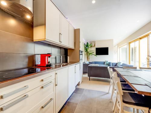 a kitchen with white cabinets and a table with chairs at Peaceful Getaway with Spa in Avelgem