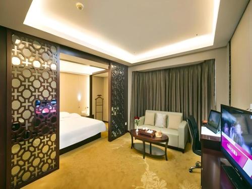 a hotel room with a bed and a tv at Quanzhou Overseas Chinese Hotel in Quanzhou