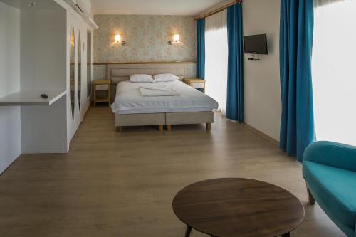 a bedroom with a bed and a table and a couch at Clementin Suits Sigacık in Siğacık