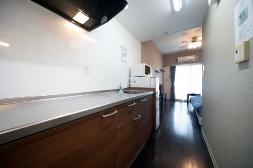 a kitchen with a sink and a refrigerator at Exsaison Chatan in Chatan