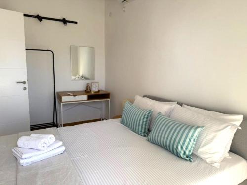 a bedroom with a bed with two pillows and a table at The Rooftop of Apartments Lungo Mare in Ulcinj