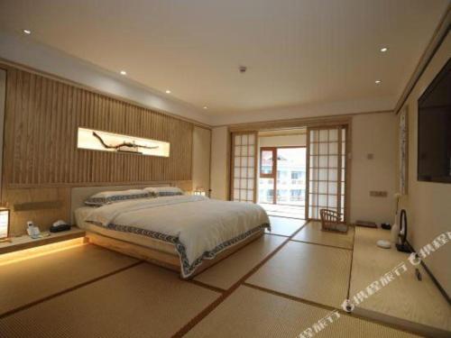 a bedroom with a large bed and a television at Kunming Dianchi Garden Hotel & Spa in Kunming