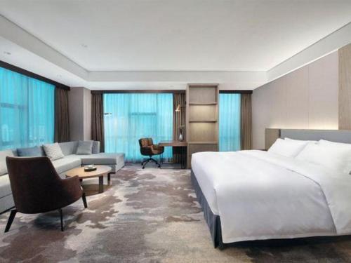 a hotel room with a large bed and a couch at Empark Grand Hotel Fuzhou in Fuzhou