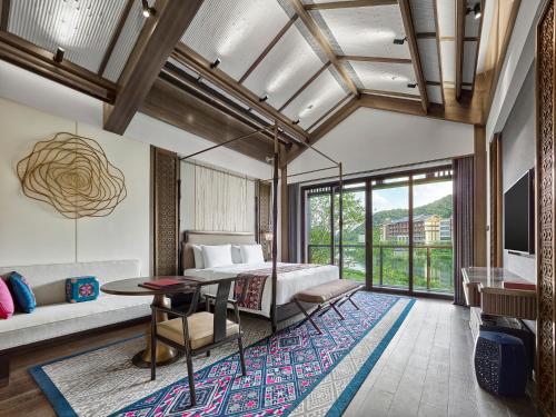 Liutangにある桂林雁山宋品酒店 Song Hotel Guilinのベッドとテーブルのあるリビングルーム