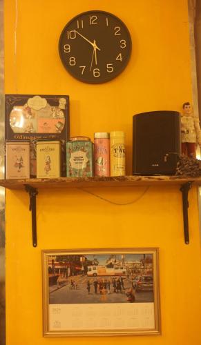a shelf with a clock and a picture on a wall at Hotel Lemong in Seoul