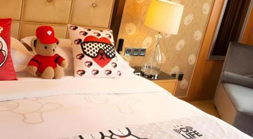 a hotel room with a teddy bear sitting on a bed at Radegast Hotel CBD in Beijing