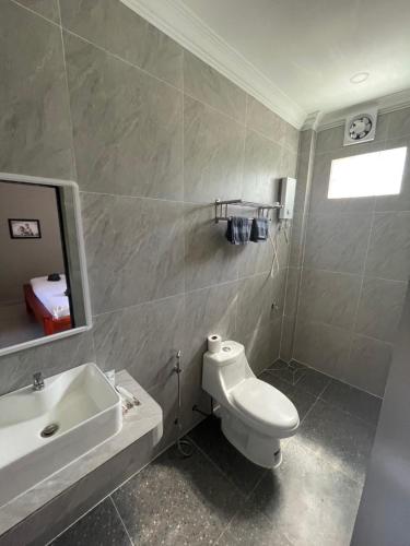 a bathroom with a white toilet and a sink at Papaya Guesthouse 
