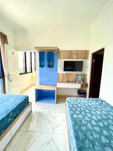 a bedroom with two beds and a kitchen at Hotel Asia Express in Lembang