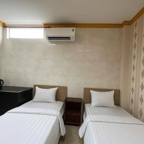 two beds sitting next to each other in a room at Hùng Anh Boutique Hotel - Nhà Ga T3 in Ho Chi Minh City