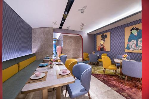 a dining room with tables and yellow chairs at Beijing Manxin Temple of Heaven North Gate Hotel in Beijing