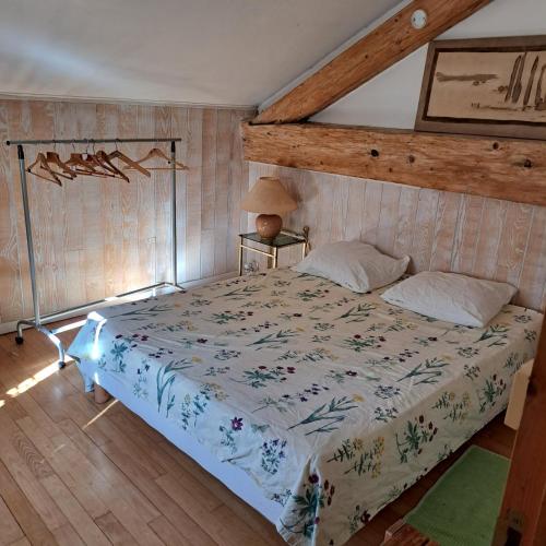 a bed in a bedroom with a wooden floor at un gîte des ânes in Bergerac
