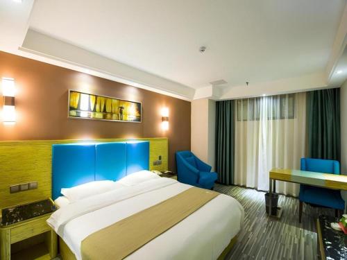 a hotel room with a large bed and a desk at GreenTree Inn Jiangxi Yingtan Jiaotong Road Central Square Business Hotel in Yingtan