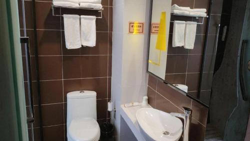 a small bathroom with a toilet and a sink at 7 Days Inn Zhangjiakou Chongli Yuxing Road in Zhangjiakou