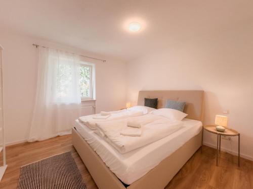 a large white bed in a room with a window at Skyrise Apartments - Zentral mit Küche, Balkon und Parkplatz in Bad Wörishofen