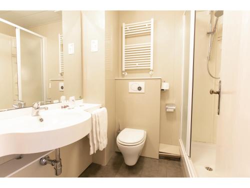 a white bathroom with a toilet and a sink at B&B HOTEL Riviera Celle Ligure in Celle Ligure