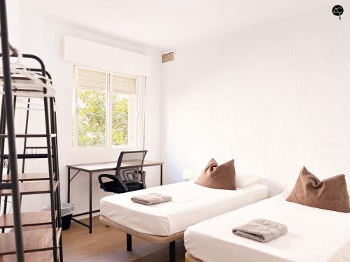 1 dormitorio con 2 camas, escritorio y escalera en Apartamento La Caleta Grupo AC Gestion, en Cádiz