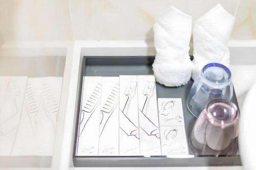 a drawer with drawings and a vase and paper at Imin Hotel in Huadu