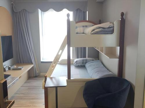 a bedroom with a bunk bed and a chair at Imin Hotel in Huadu