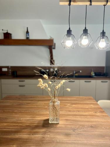 a vase with flowers sitting on a table with lights at L'Echappée familiale en bord de mer in Plozévet