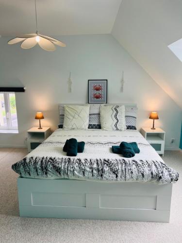 a bedroom with a white bed with two towels on it at L'Echappée familiale en bord de mer in Plozévet