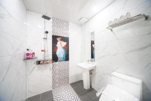 a white bathroom with a sink and a toilet at SH Hotel in Mokpo
