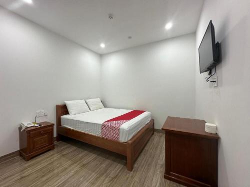 a small bedroom with a bed and a tv at Motel Phuong Linh in Da Nang